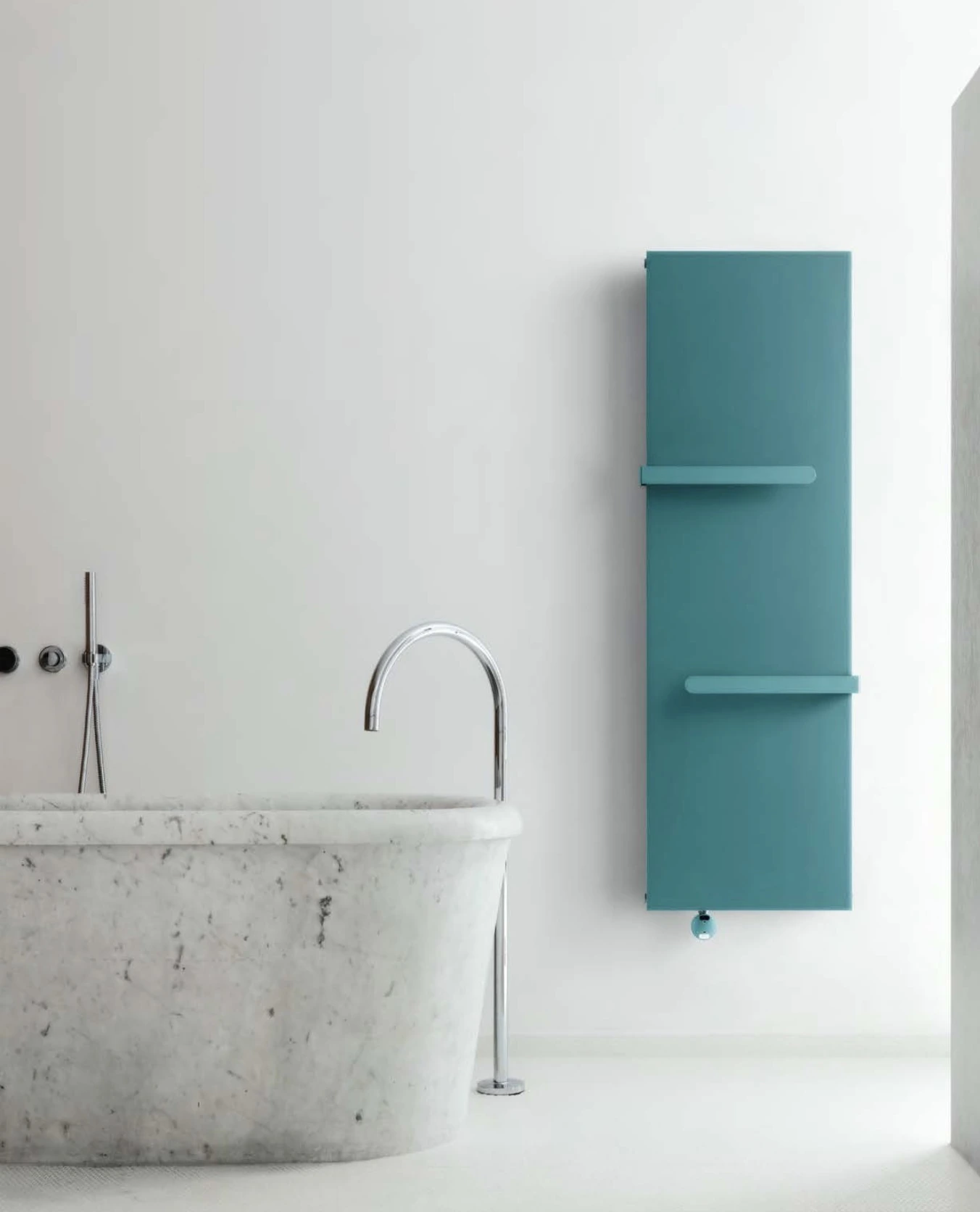 Türkisfarbener Designheizkörper von Caleido neben einer Badewanne